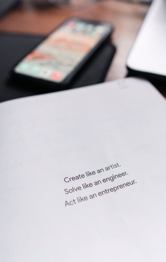 Close-up view of an inspirational quote on paper with a smartphone in the background.