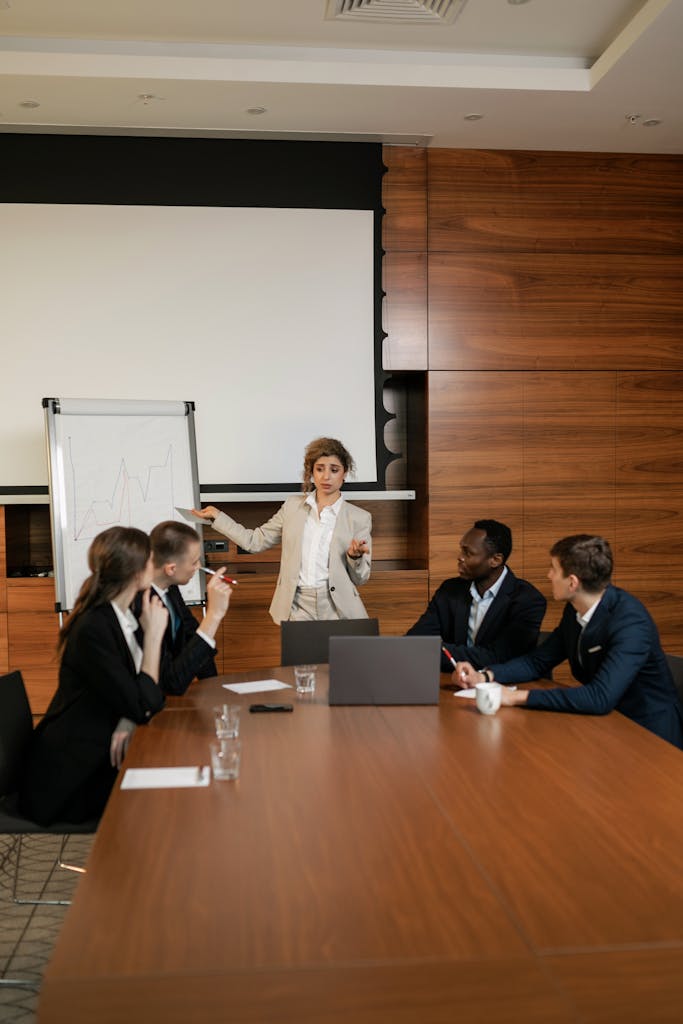 Team collaborating around a table with a presentation in an office setting.